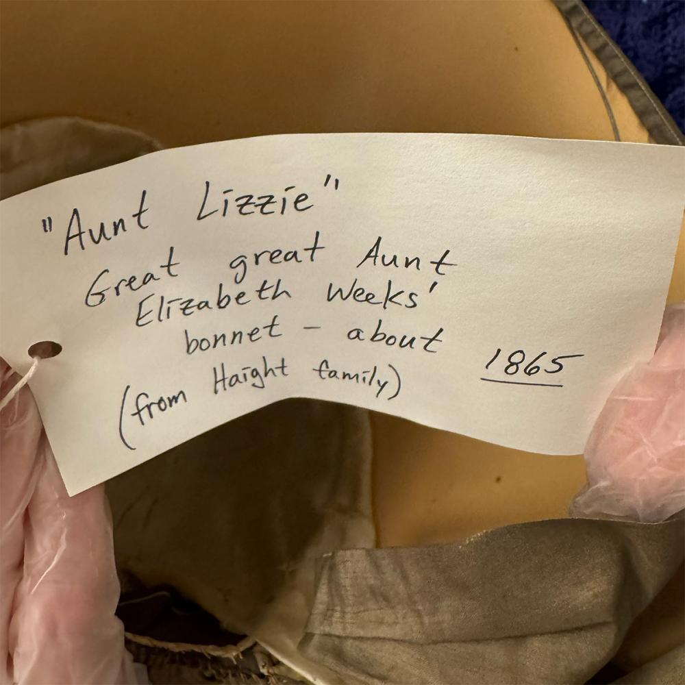 A tag attached to an old Quaker bonnet. The tag reads: "Aunt Lizzie" Great great Aunt Elizabeth Weeks' bonnet -- about 1865 (from Haight family) 
Nancy Hadley-Jaffe says this bonnet is from Quarterly Meeting/15th Street Meeting's small collection of plain Quaker dress from the mid 19th century.